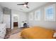 Bright bedroom featuring a ceiling fan, desk, and an ensuite bathroom with warm wood look flooring at 20198 E Rosa Rd, Queen Creek, AZ 85142