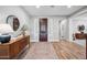 Welcoming entryway with a wood dresser, mirror, hardwood floors, and a view to the home's interior at 20198 E Rosa Rd, Queen Creek, AZ 85142