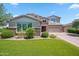Attractive home with stone accents, lush landscaping, a well-maintained lawn, and a spacious driveway at 20198 E Rosa Rd, Queen Creek, AZ 85142