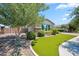 Charming front yard with green grass, decorative shrubs, and a beautiful tree at 20198 E Rosa Rd, Queen Creek, AZ 85142