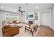 Cozy living room with a brick fireplace, built-in shelves, a ceiling fan, and a leather couch at 20198 E Rosa Rd, Queen Creek, AZ 85142