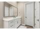 Bright bathroom with a large mirror above the white vanity, complemented by modern fixtures and wood-look flooring at 23448 N 76Th Pl, Scottsdale, AZ 85255