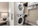 Efficient laundry area with a stacked washer and dryer, and shelving for organized storage solutions at 23448 N 76Th Pl, Scottsdale, AZ 85255