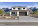 Two-story home featuring desert landscaping, a gray garage door, and situated in front of beautiful mountains at 24238 W Hacienda Ave, Buckeye, AZ 85326