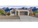 Charming single-story home featuring a two-car garage, desert landscaping, and a picturesque mountain backdrop at 24264 W Hacienda Ave, Buckeye, AZ 85326