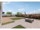 Desert landscaped backyard with low maintenance gravel, artificial turf sections, and a stone fire pit at 25727 N 161St Ave, Surprise, AZ 85387