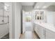 Bright bathroom with double vanity, white cabinets, wood-look flooring, and accessible shower at 25727 N 161St Ave, Surprise, AZ 85387