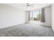 Spacious bedroom with gray carpet, ceiling fan, and large window allowing natural light at 25727 N 161St Ave, Surprise, AZ 85387