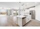 Bright, open-concept kitchen with a large island, stainless steel appliances, and stylish pendant lighting at 25727 N 161St Ave, Surprise, AZ 85387