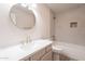 Modern bathroom features a round mirror, white cabinets, quartz counters, and tiled shower at 2647 N Miller Rd # 6, Scottsdale, AZ 85257