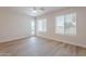 Bedroom features wood-look floors, neutral walls, white trim, blinds, and an exterior door at 2647 N Miller Rd # 6, Scottsdale, AZ 85257