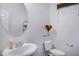 Bathroom featuring a round mirror, toilet, and flower accents for a fresh look at 2715 N 73Rd Dr, Phoenix, AZ 85035