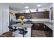 Modern kitchen with dark cabinets, granite counters, stainless steel appliances, and an island at 2715 N 73Rd Dr, Phoenix, AZ 85035