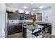 Modern kitchen with dark cabinets, granite counters, stainless steel appliances, and an island at 2715 N 73Rd Dr, Phoenix, AZ 85035