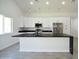 Bright kitchen features white cabinets, stainless steel appliances, and a large island with black marble countertop at 2790 W Cholla St, Apache Junction, AZ 85120