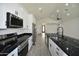 Bright kitchen features white cabinets and black hardware, stainless steel appliances, and a large island with a black countertop at 2790 W Cholla St, Apache Junction, AZ 85120