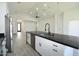 Bright kitchen features white cabinets and black hardware, stainless steel appliances, and a large island with a black countertop at 2790 W Cholla St, Apache Junction, AZ 85120