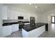 Bright kitchen features white cabinets, stainless steel appliances, and a large island with a black marble countertop at 2790 W Cholla St, Apache Junction, AZ 85120