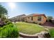 Well-maintained backyard with green grass, landscaping, and a covered patio area at 3147 E Vallejo Dr, Gilbert, AZ 85298