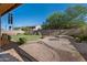 Spacious backyard featuring a lush lawn, brick patio, mature tree, and privacy fence at 3147 E Vallejo Dr, Gilbert, AZ 85298