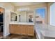 Bathroom features a large mirror over double sinks with a tub and natural light at 3147 E Vallejo Dr, Gilbert, AZ 85298