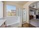 Bright bathroom featuring tub and separate shower; window overlooks backyard at 3147 E Vallejo Dr, Gilbert, AZ 85298