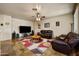 Spacious living room featuring leather sofas, stylish rug, and a ceiling fan at 3147 E Vallejo Dr, Gilbert, AZ 85298