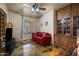 Comfortable living room featuring a bright red sofa, built-in cabinets, and modern ceiling fan at 3147 E Vallejo Dr, Gilbert, AZ 85298
