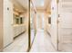 Hallway view of a bright bathroom featuring double vanities, mirrored sliding door closets, and tiled floors at 333 E Caribbean Ln, Phoenix, AZ 85022