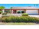 Well-maintained home featuring desert landscaping with green grass, red flowers and a red tile roof at 333 E Caribbean Ln, Phoenix, AZ 85022
