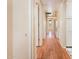 Hallway featuring wood floors, white walls, and doors leading to various rooms in the home at 333 E Caribbean Ln, Phoenix, AZ 85022