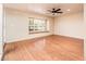 Spacious living room featuring wood floors, neutral colors, a ceiling fan and a large window at 333 E Caribbean Ln, Phoenix, AZ 85022