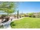Lush backyard features built-in grill, manicured lawn, mature trees and desert landscaping at 33823 N 2Nd St, Phoenix, AZ 85085