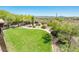 Expansive backyard featuring lush green grass, mature trees, and desert views at 33823 N 2Nd St, Phoenix, AZ 85085