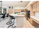 Bright kitchen with light wood cabinets, stainless steel appliances, a breakfast bar, and an adjacent dining area at 33823 N 2Nd St, Phoenix, AZ 85085