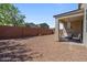 Spacious backyard featuring a covered patio with chairs, perfect for outdoor relaxation and entertaining at 37166 N El Morro Trl, San Tan Valley, AZ 85140