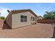 View of the backyard showing the low maintenance landscaping and covered patio with outdoor seating at 37166 N El Morro Trl, San Tan Valley, AZ 85140