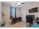 Bedroom with brown carpet, ceiling fan, window, and desk at 37166 N El Morro Trl, San Tan Valley, AZ 85140