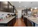 Modern kitchen featuring granite countertops, dark cabinets, and stainless steel appliances at 37166 N El Morro Trl, San Tan Valley, AZ 85140