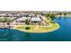An aerial view showcases a home's premium waterfront lot, manicured lawn, and proximity to the lake at 37456 W Vera Cruz Dr, Maricopa, AZ 85138