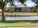 A charming home with a backyard overlooking a pond, featuring lush landscaping and a wrought iron fence at 37456 W Vera Cruz Dr, Maricopa, AZ 85138