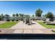 An inviting backyard patio offers serene water views, a brick-paved area, artificial turf and comfortable outdoor seating at 37456 W Vera Cruz Dr, Maricopa, AZ 85138