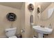 Powder room with a pedestal sink, decorative accents, and neutral tones at 3863 S Posse Trl, Gilbert, AZ 85297