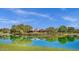 Water view of the Power Ranch clubhouse, landscaping and trees on a sunny day with blue sky at 3863 S Posse Trl, Gilbert, AZ 85297