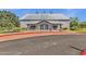 Community center building with stone accents, metal roof, and manicured landscaping at 3863 S Posse Trl, Gilbert, AZ 85297