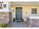 Inviting front entrance showcasing stone pillars, manicured plants, and a stylish gray-colored door at 3863 S Posse Trl, Gilbert, AZ 85297