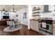 Open kitchen and dining area with stainless steel appliances, granite counters and a modern chandelier at 3863 S Posse Trl, Gilbert, AZ 85297