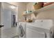 Laundry room with a washer, dryer, shelving, and access to the hallway and other rooms of the house at 3863 S Posse Trl, Gilbert, AZ 85297