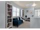 Cozy living room with bookshelves, a comfortable sofa, and natural light from a window at 3863 S Posse Trl, Gilbert, AZ 85297