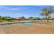 Resort-style pool area with umbrellas, lounge chairs, and shallow wading area with geometric pavers at 3863 S Posse Trl, Gilbert, AZ 85297